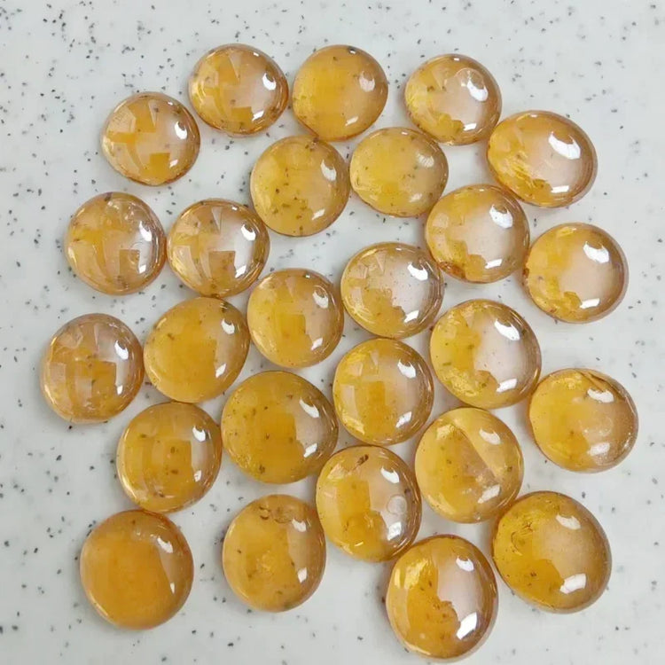 Collection of polished yellow amber stones on a speckled white surface