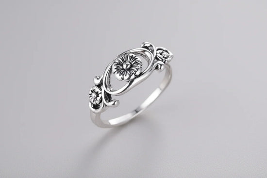 Silver retro floral hollow flower ring on display