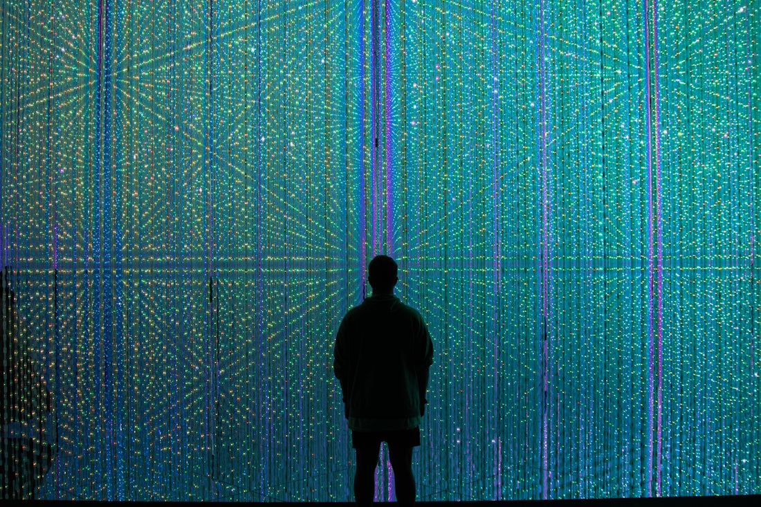 a person standing in front of a wall of lights