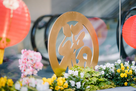 a close up of a metal sign near flowers