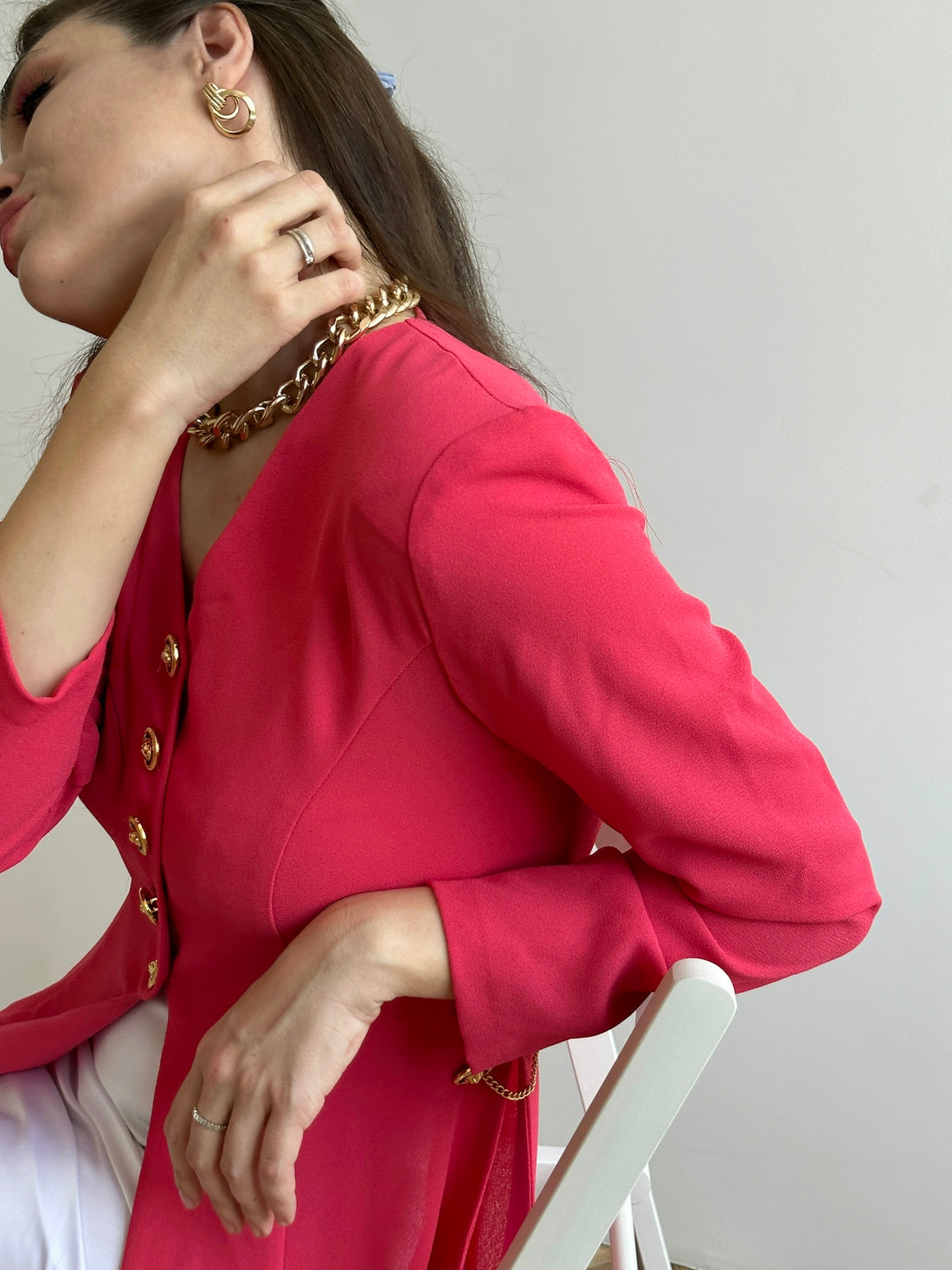 a woman sitting in a chair with her hand on her neck