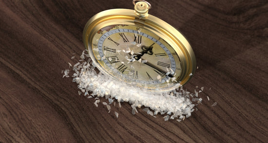 A gold clock sitting on top of a wooden table