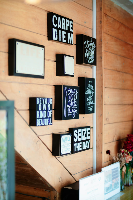 A wooden wall with a bunch of signs on it