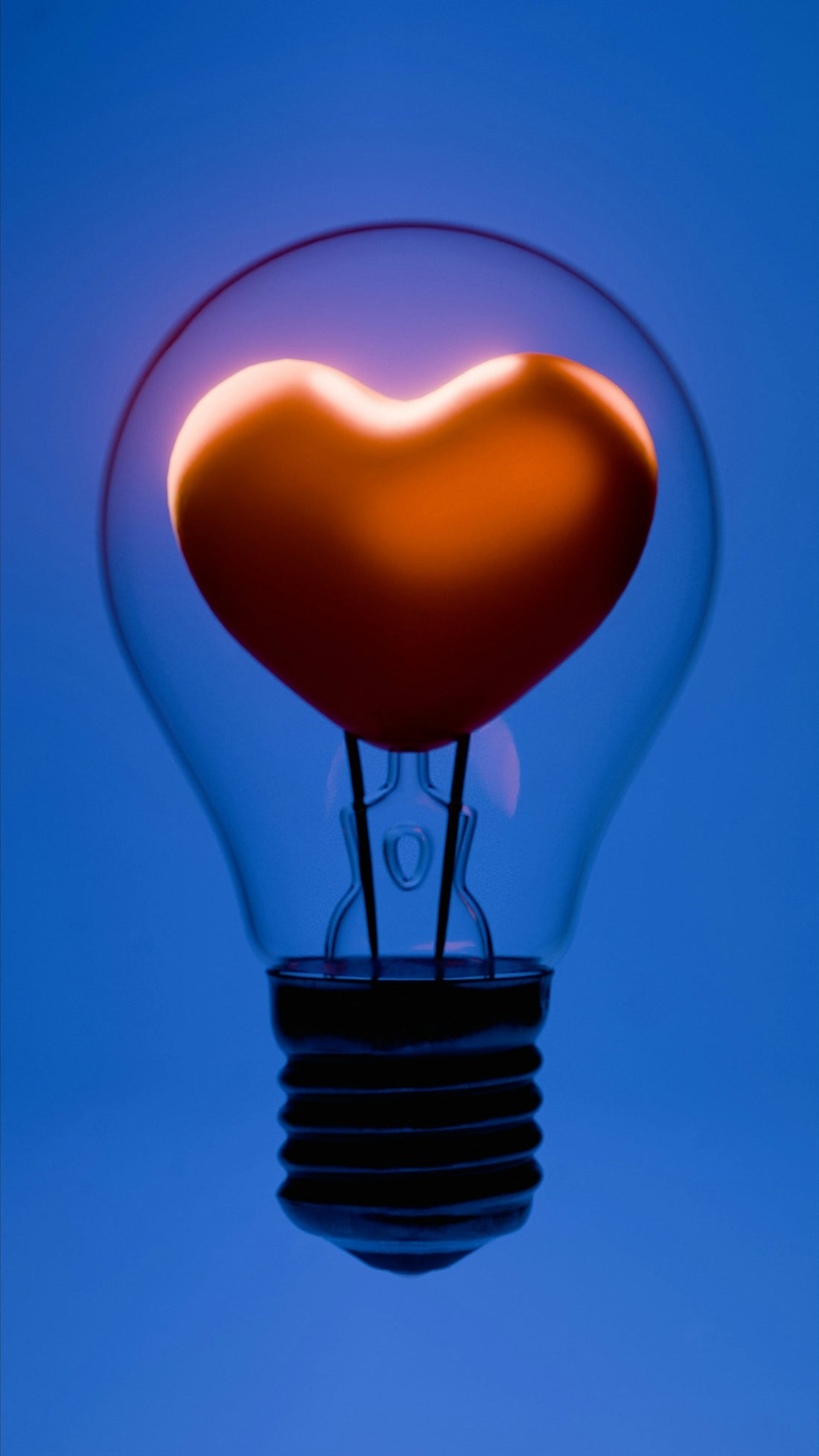 A glowing heart inside a lightbulb.