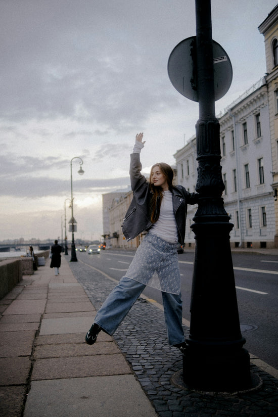 Woman posing by lamppost on city street