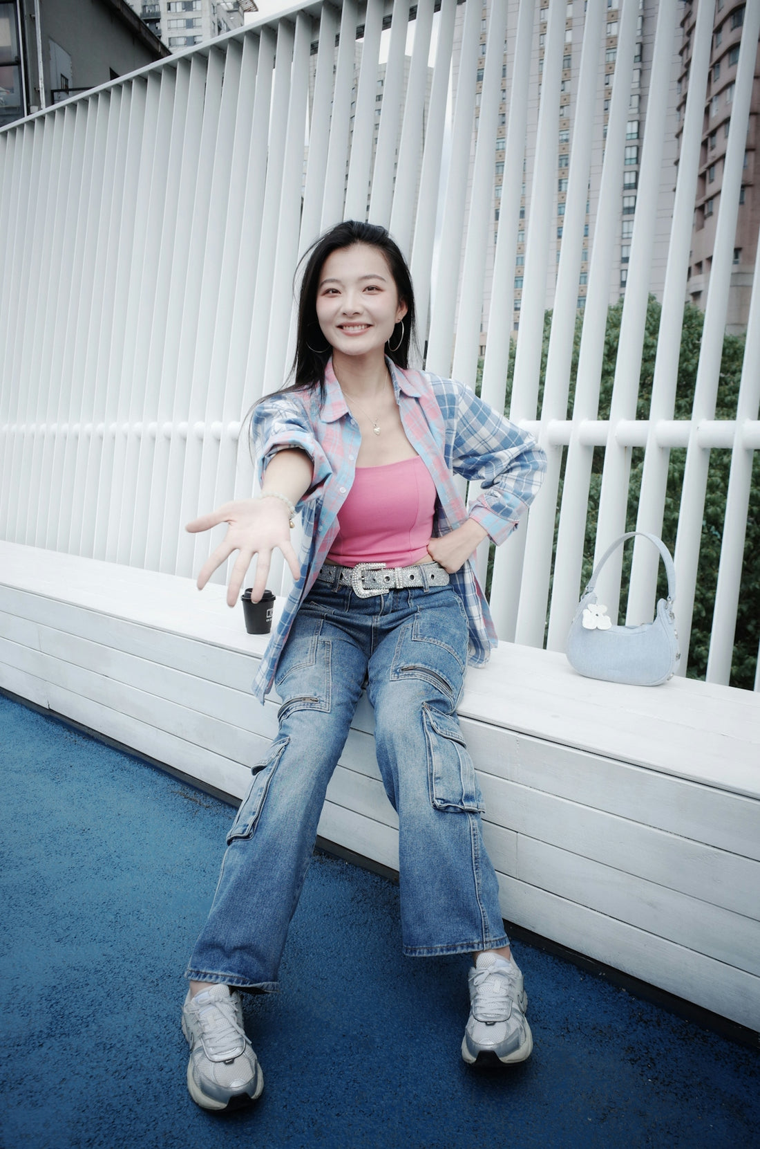Young woman in casual clothes sits on a bench.