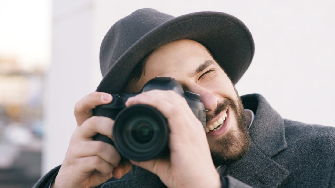 Man in hat taking a picture with a camera