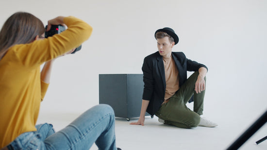Model poses for photographer in studio setting