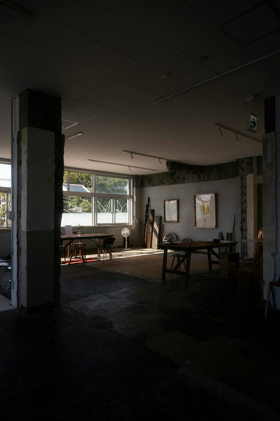 Sunlit art studio with tables and artwork