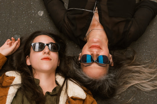 Two women with sunglasses lying down together