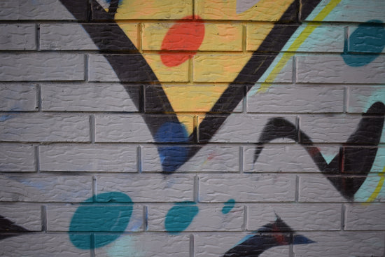 Graffiti art with abstract shapes on brick wall