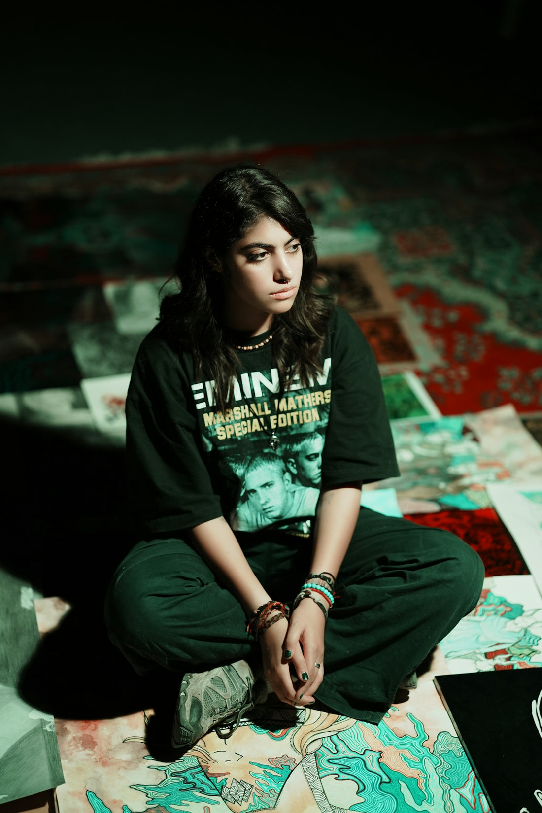 Young woman in eminem t-shirt sitting on floor.