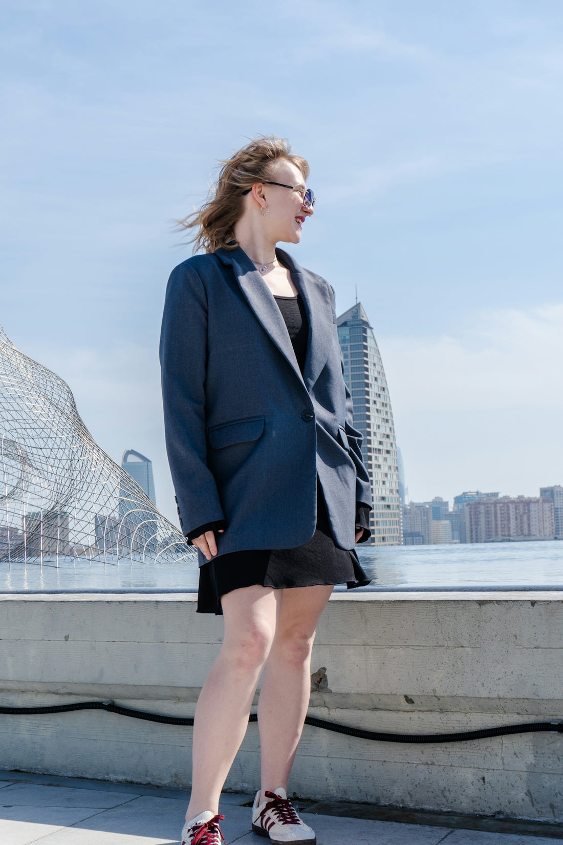 Woman in blazer and dress looking away outdoors