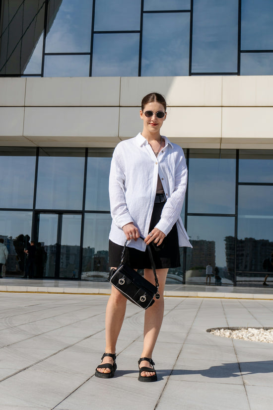 Woman in white shirt and black skirt with handbag