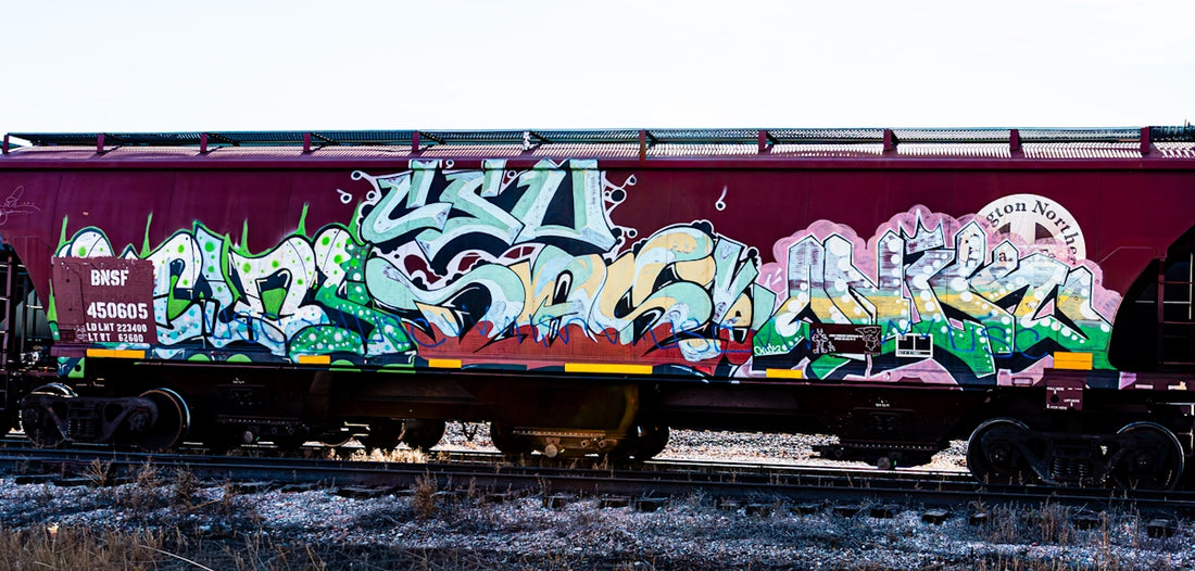 Graffiti art covers a maroon train car
