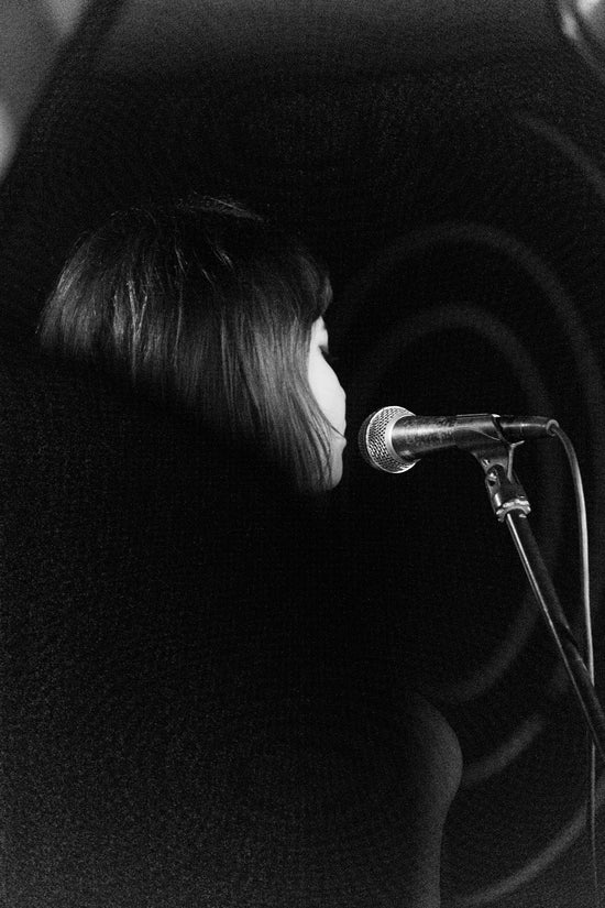 Woman singing into microphone in dark room