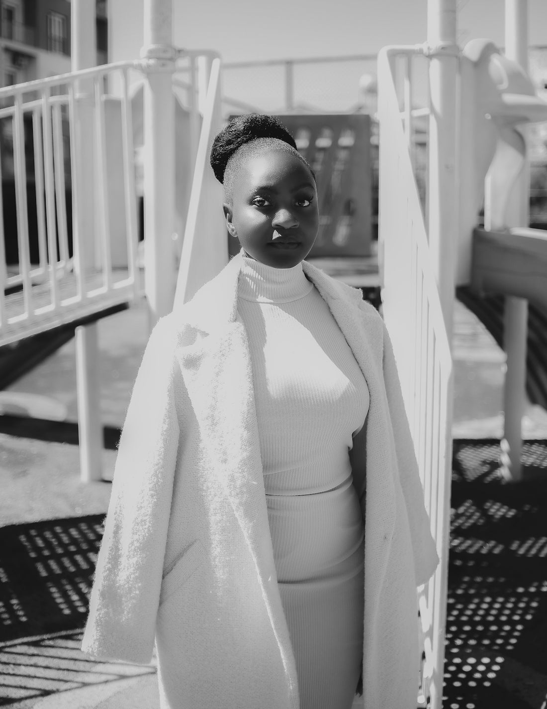 A young woman stands on a playground structure.