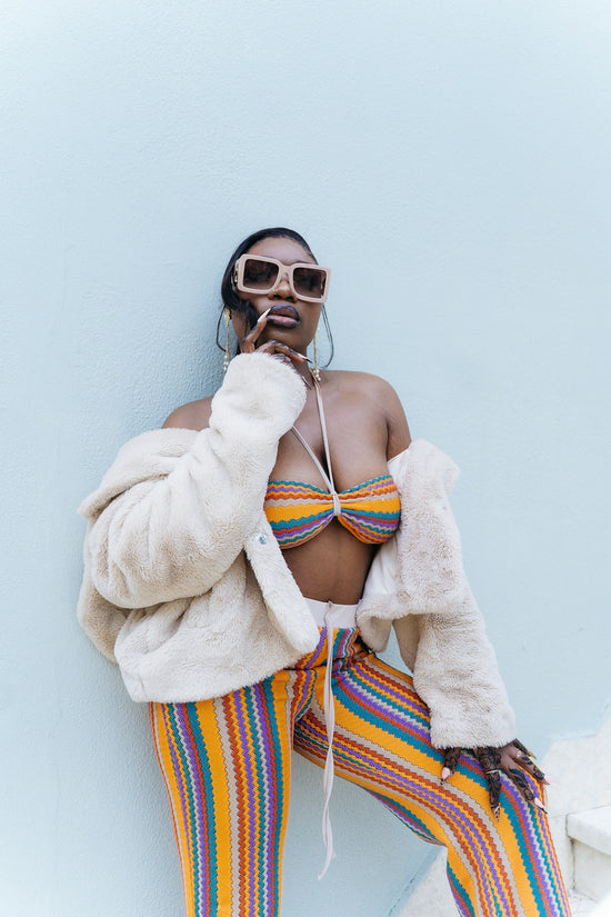 Woman in colorful striped outfit and fur coat
