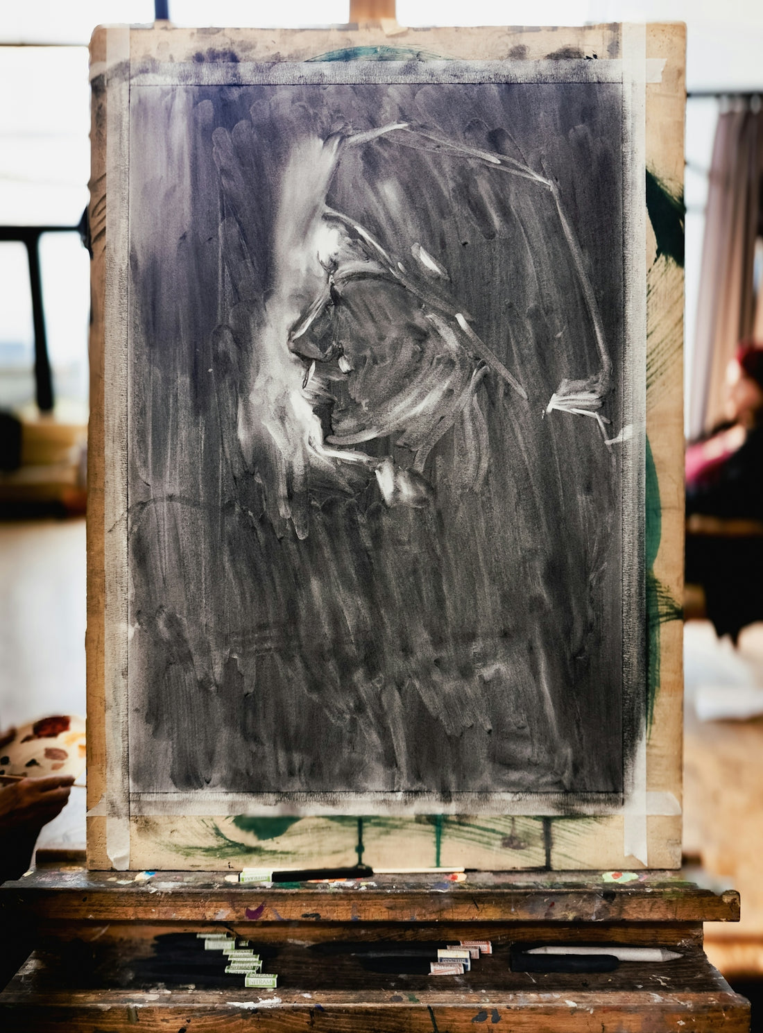 Charcoal sketch of a face on an easel