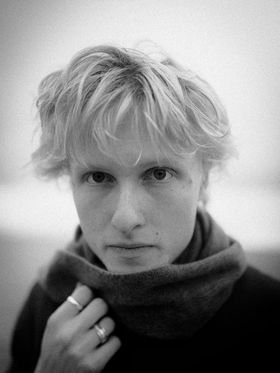 Young man with blond hair wearing a scarf
