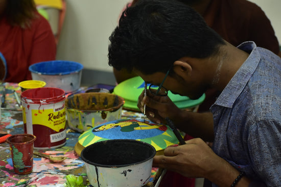 Man painting a colorful object with a brush