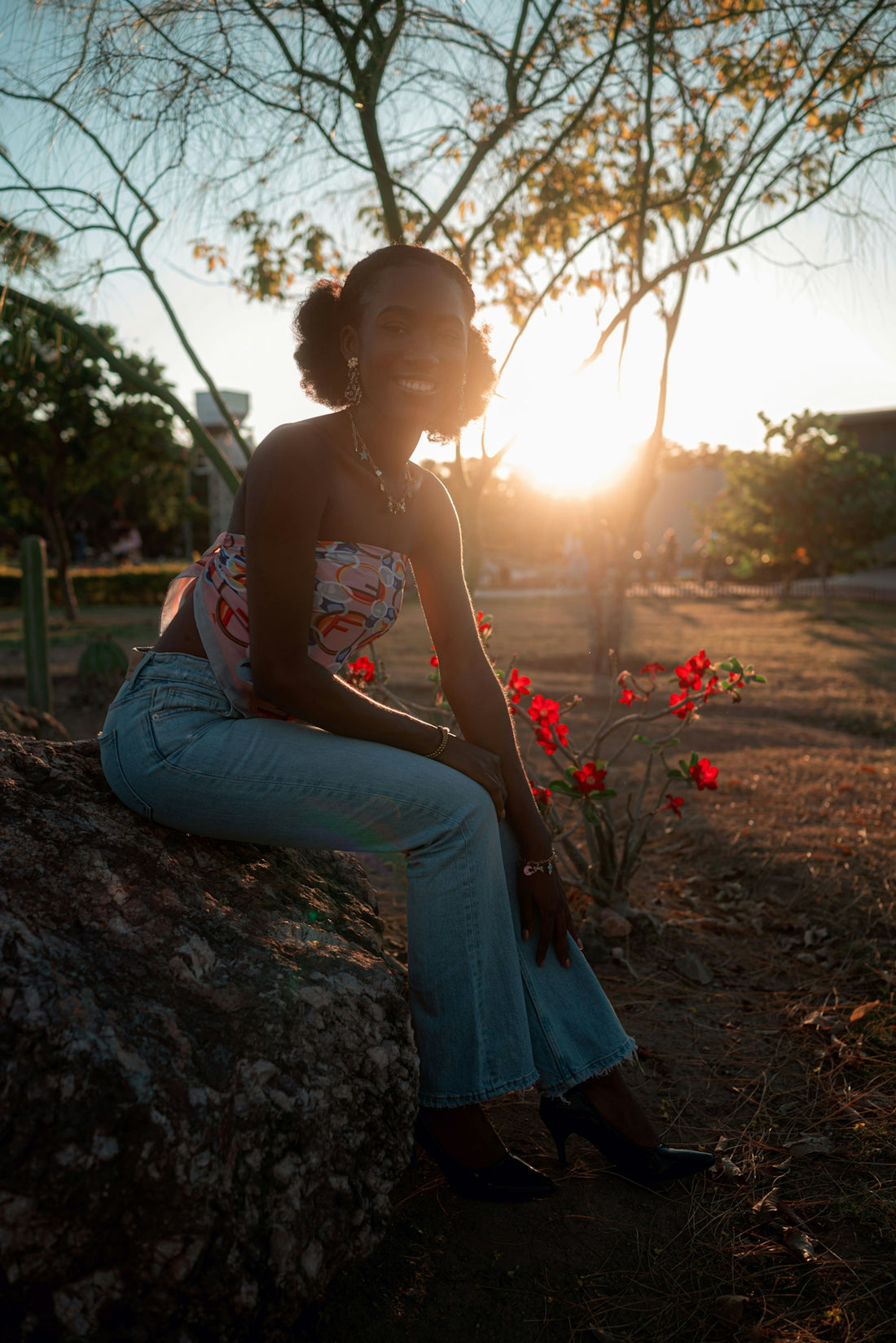 Woman sitting on rock during sunset