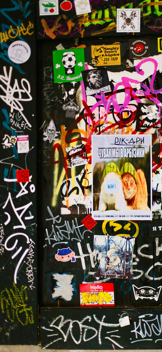 A wall covered in graffiti and stickers