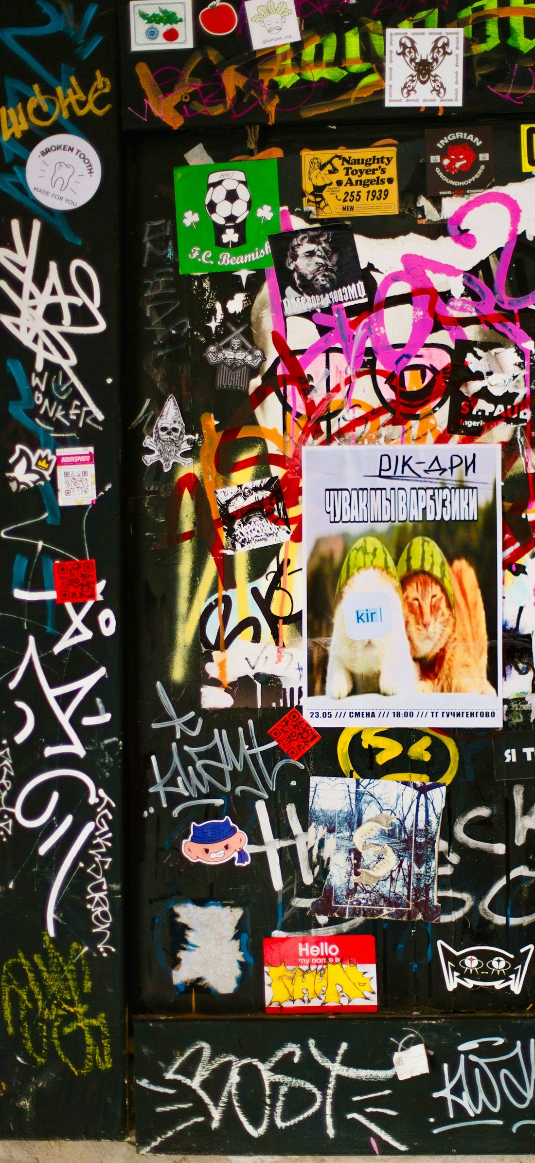 A wall covered in graffiti and stickers