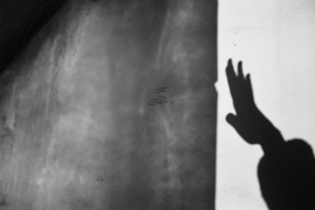 Shadow of a hand against a textured wall