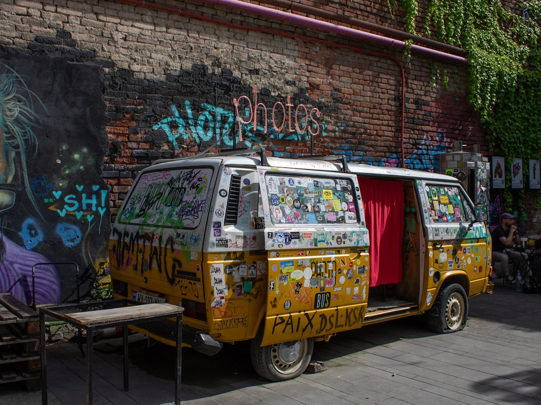 Yellow van covered in stickers and graffiti