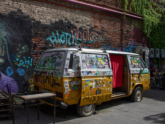 Yellow van covered in stickers and graffiti