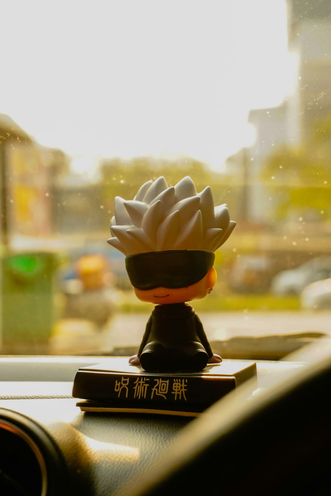 A figurine with a blindfold sits on a dashboard.