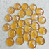 Collection of polished yellow amber stones on a speckled white surface