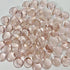 Smooth polished round rose quartz gemstones on a light background, semi-transparent pink crystals