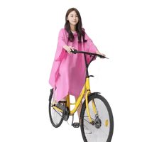 Woman in Colorful Waterproof Long Raincoat on Yellow Bicycle